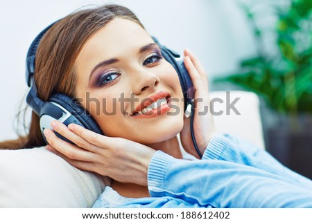 Happy smiling woman listening music with headphones. Smiling girl relax at home.