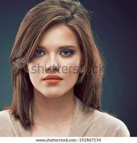 Woman beauty face against dark studio background. Close up
