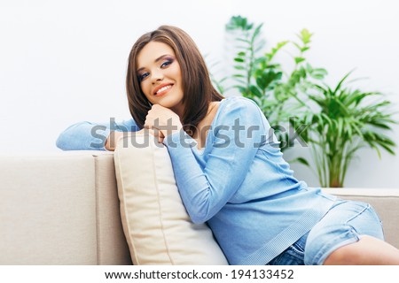 Portrait of young woman sitting on couch at home. Relaxing girl.
