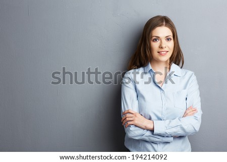 Crossed arms portrait of smiling business woman in studio.