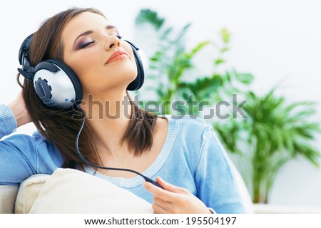 Music woman. Girl listening music with headphones. Home portrait.