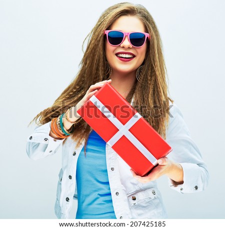 Fashion model with red gift. Rock style. Young woman hipster style with pink sun glasses.
