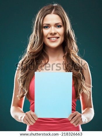 beautiful female model holding blank white board standing against gray background