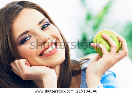 Toothy smiling young woman close up face portrait with green apple.