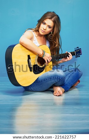teenager girl guitar play . young model with long hair sitting on a floor.