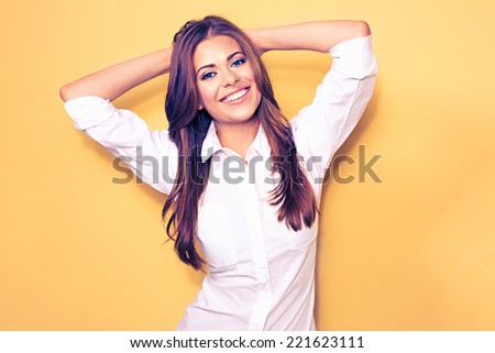 happy emotional business woman portrait . smiling model, white shirt. yellow background.