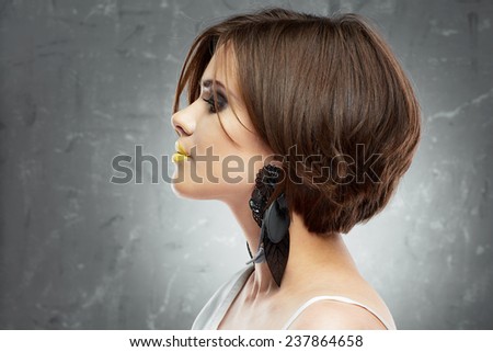 profile face portrait of sexy woman with medium length hair . bob haircut. big black earring.