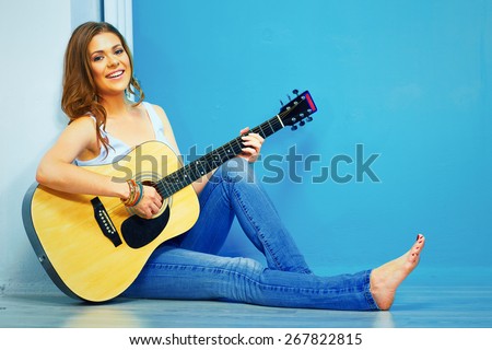 teenager girl guitar play . young model with long hair sitting on a floor.