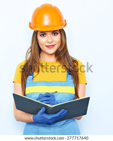 Engineer woman smile, writes in  business paper. Builder uniform coveralls. Orange protective helmet.