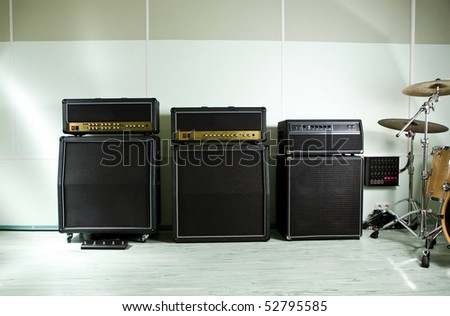 Three guitar amplifier standing on music recording studio with drum set