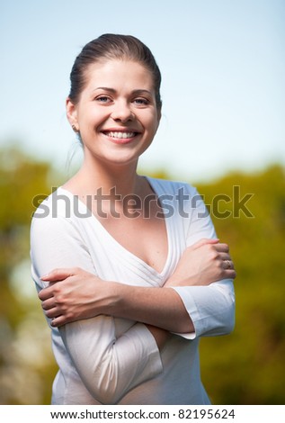 Woman portrait on summer tree background. Outdoor portrait with big smile.