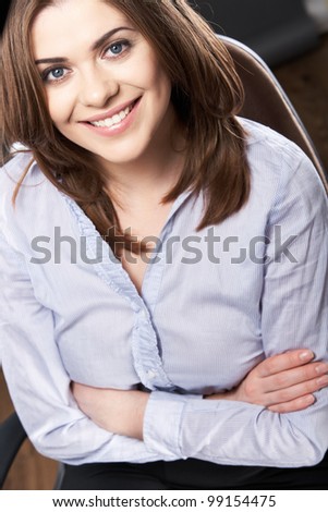 Isolated woman portrait. Smiling and happy girl over gray background sitting on a chair