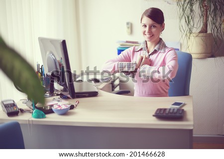 Portrait of young caucasian business woman in pink vest at her office