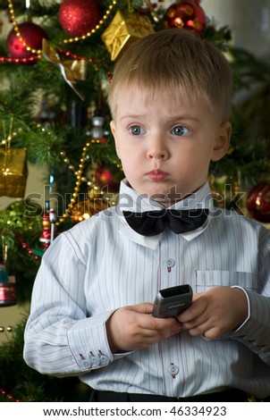 It is necessary to call the daddy. Thoughtful little boy hold in hands a phone.