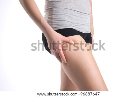 Cropped image of a female holding thigh for skin fold test. Isolated on white background.