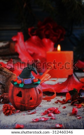 pumpkin on a background of dry plants and candles for Halloween