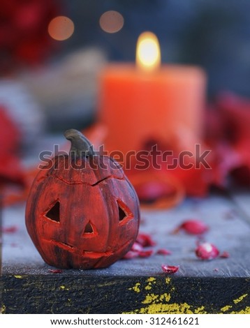 pumpkin on a background of dry plants and candles for Halloween