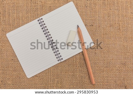 note book ,pencils,eraser on sack background