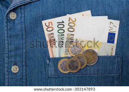 euro bank note and coin in jeans shirt pocket