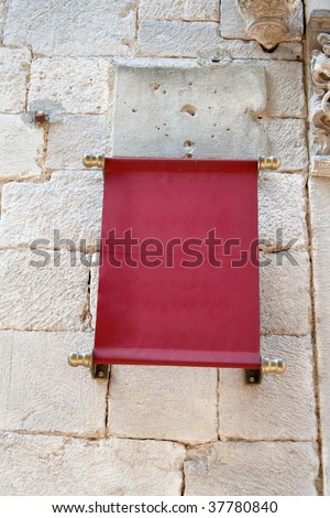 sign of the red cloth on an old stone wall