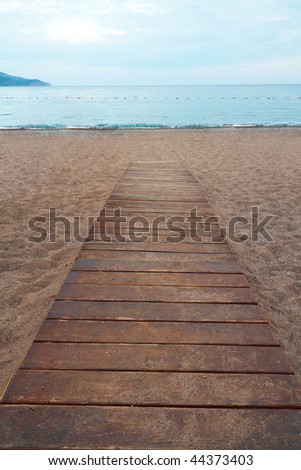 Wooden boards path on the sand on a beach