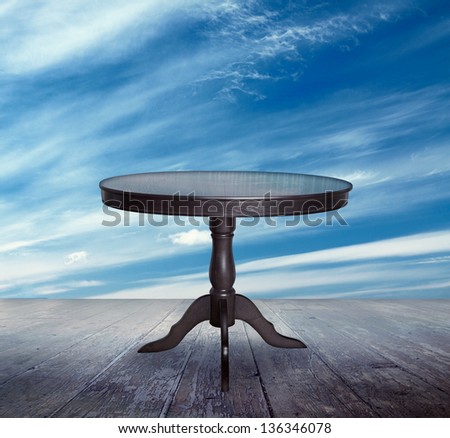 antique table table on the balcony. blue sunset sky and wooden floor, background.