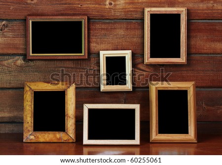 old photo frames on the wooden wall and table