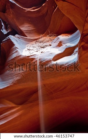 Light play with the stream of falling sand from the red rock of the Antelope Canyon