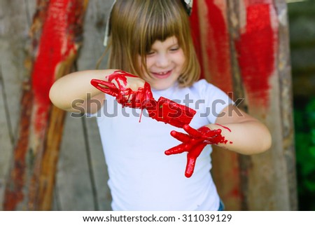 Girl with a brush with red paint, paint the outside barn