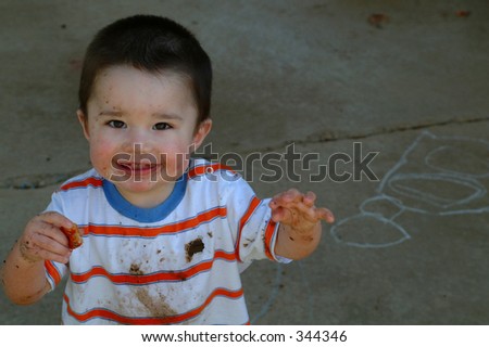 Toddler boy dirty from playing in the mud
