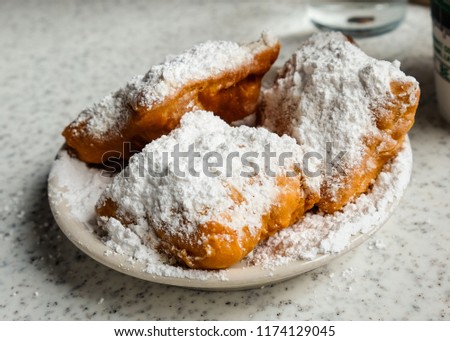 Fresh beignets come out of the fryer, topped with powdered sugar, ready to eat. Stockfoto © 