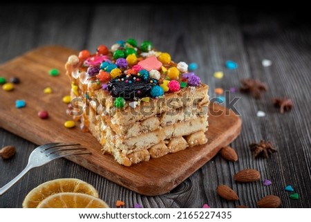 Turron de Doña Pepa, traditional national Peruvian dessert served on the religious feast of Señor de los Milagros, decorated with confetti and nuts on a wooden board with a fork and dry orange slices Foto stock © 