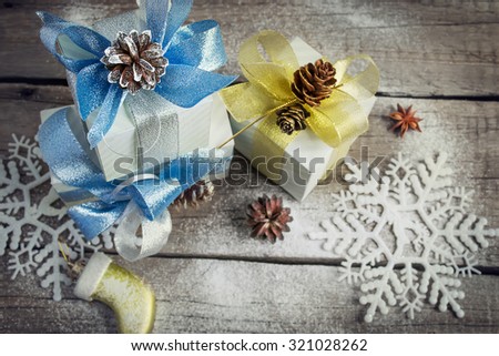 New Year\'s box with gifts and bows, fir cones, snowflakes and Christmas toy on old boards