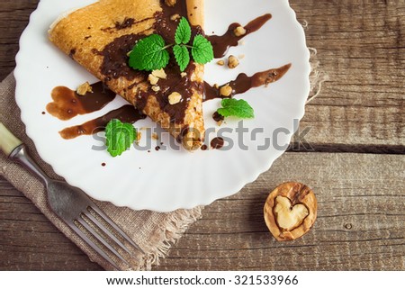 Pancake with chocolate and nuts in the form of a heart. Food concept Valentine\'s Day