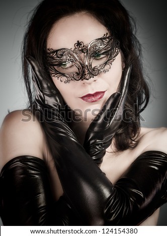 Venetian Mask. A pretty retro girl in black wearing a cute hat and a scarf.