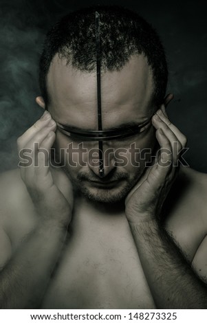 Metal, concept of fear and terror, naked man with hardware in the face