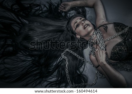 Chained, Fashion shoot of young brunette woman in fetish dress, long hair