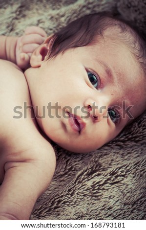 Newborn peacefully sleeping, picture of a baby curled up sleeping on a blanket
