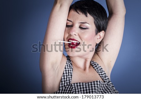 Diet, happy young woman with lollypop  in her mouth on blue background