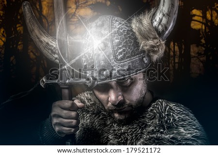 War, Viking warrior, male dressed in Barbarian style with sword, bearded
