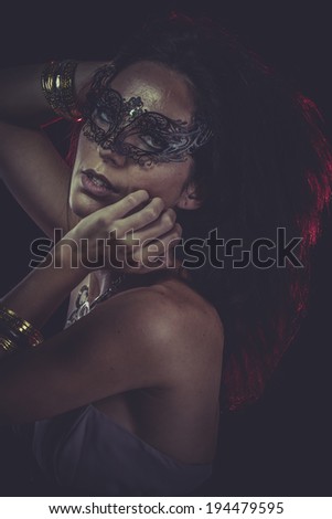Party brunette woman with golden jewelry and red light on hair
