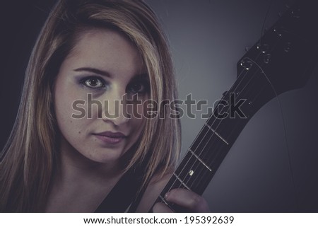 Beautiful blonde with black electric guitar