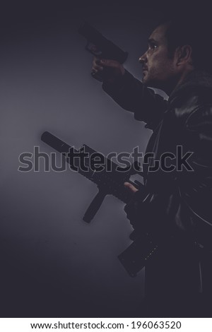 danger, portrait of stylish man with long leather jacket, gun armed
