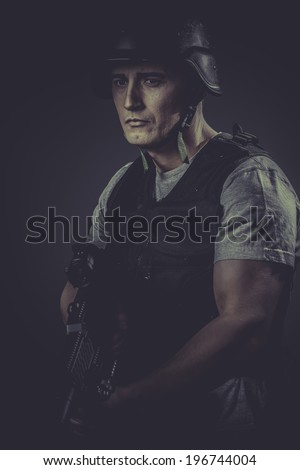 Recreation, paintball sport player wearing protective helmet aiming pistol ,black armor and machine gun