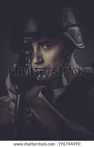 Weapon, paintball sport player wearing protective helmet aiming pistol ,black armor and machine gun