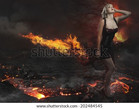 Beautiful blonde in a desolate landscape with a volcano of lava and fire river