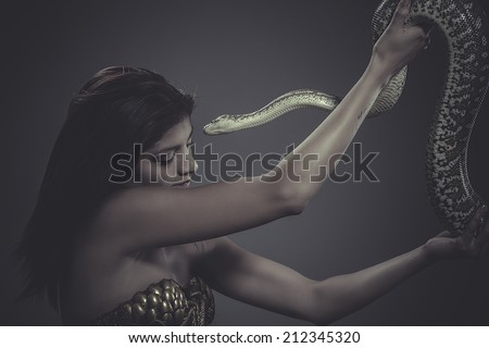 exotic, brunette woman posing with a python snake Australian
