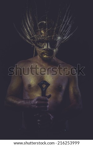 dramatic golden bodypaint, man with gold helmet, ancient warrior deity