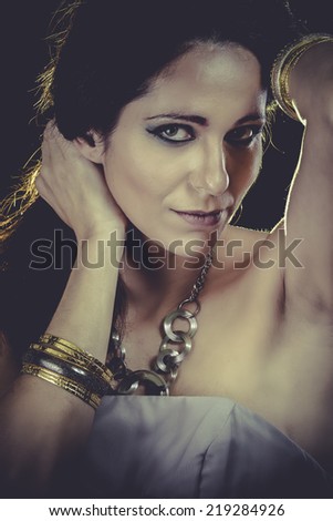 Elegant woman with golden light, gold and silver jewelry