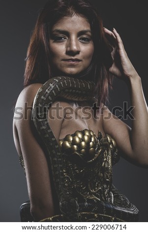 Risk, Sensual tattooed woman with big snake and iron corset